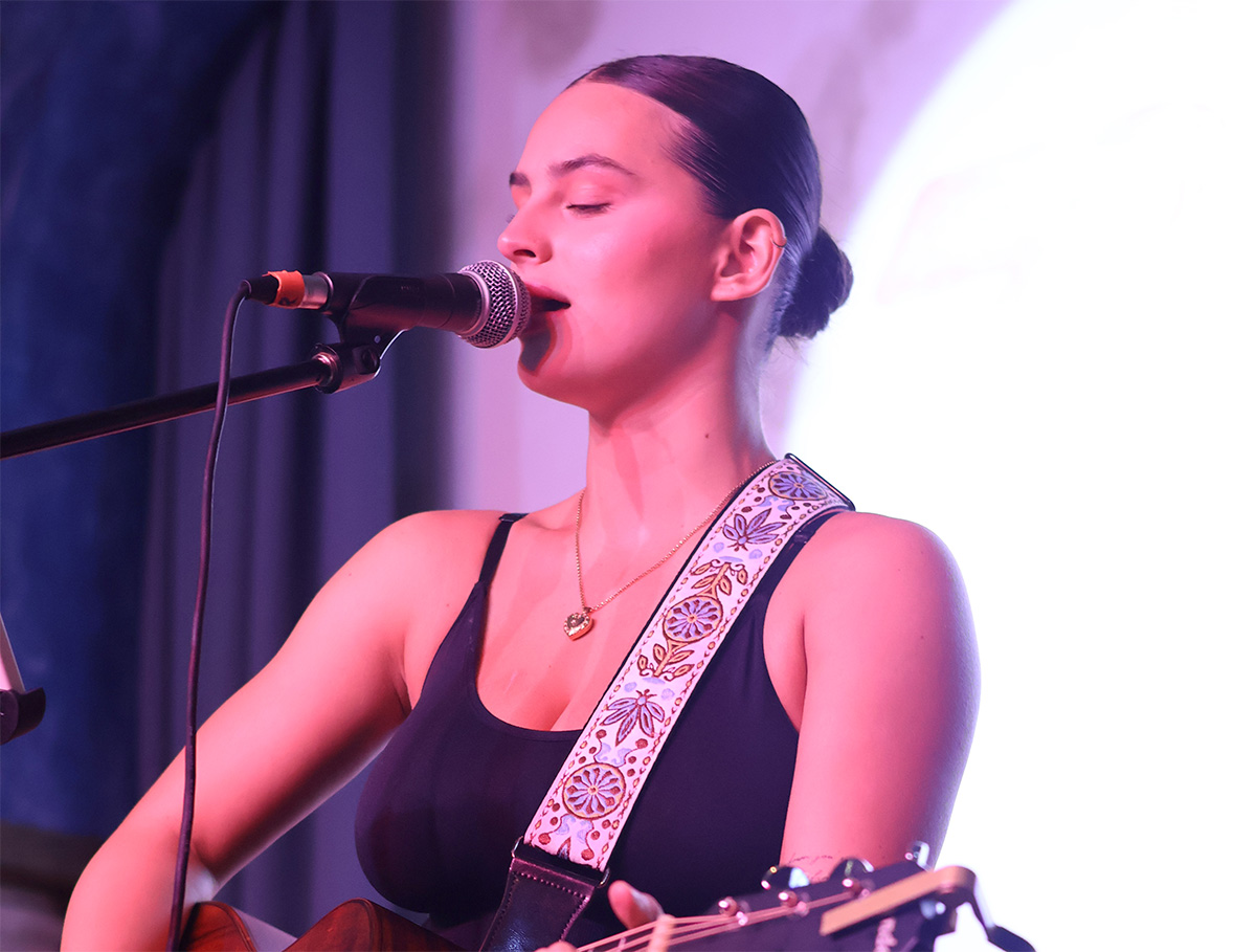 A female guitarist performing at Seed Sounds Weekender